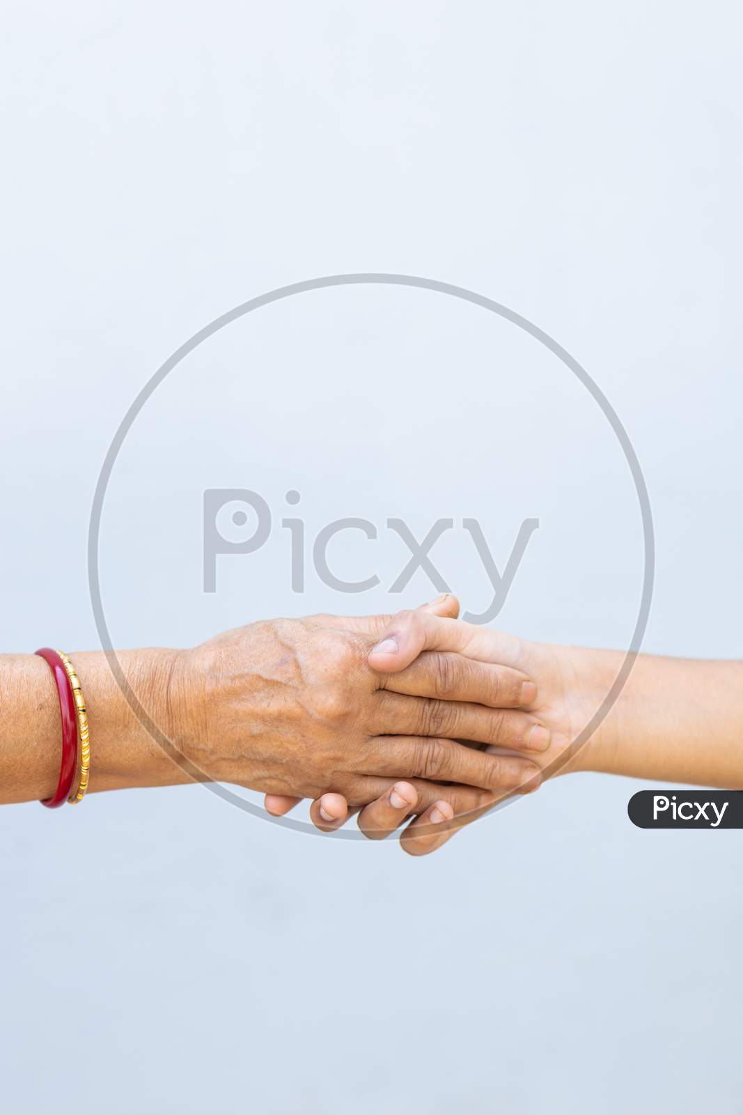 Senior Woman And Child Holding Hands Against Plain Background