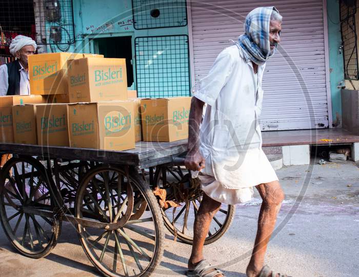 Pushkar, Rajashtan /India - 07/11/2019  old man pulling cart loaded with boxes