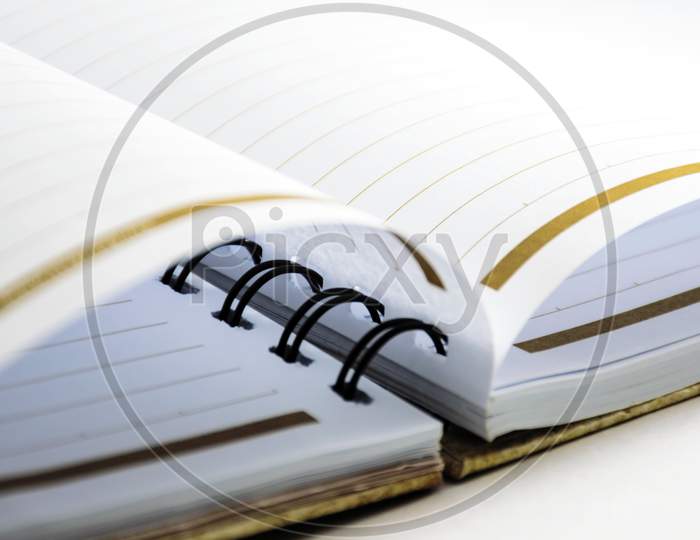 A close view of an open diary or notepad with  rings isolated on a white background