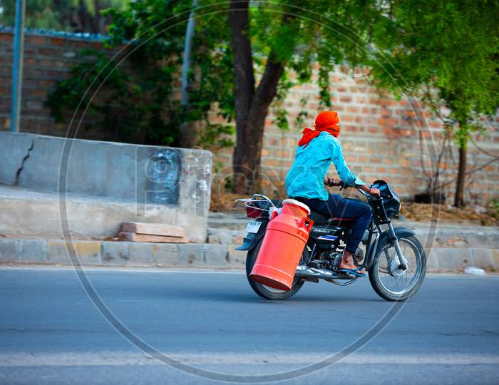 Jodhpur, Rajashtbn, India. 30 March 2020. Man Riding Bike To Sell Milk To The Customers, Coronavirus, Covid-19 Outbreak In India. Lockdown / Curfew In The Country.