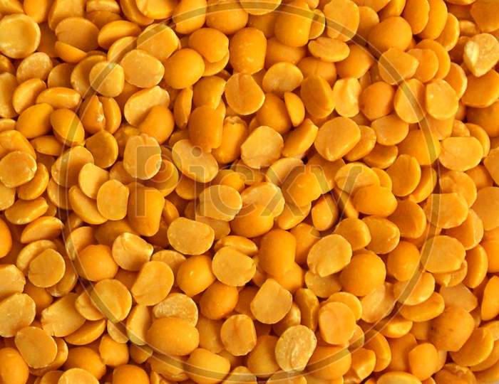 Yellow chopped peas close up,background of yellow peas.Yellow split chickpea peas boot chana dal lentil pulse bean on white background,top view.healthy food.