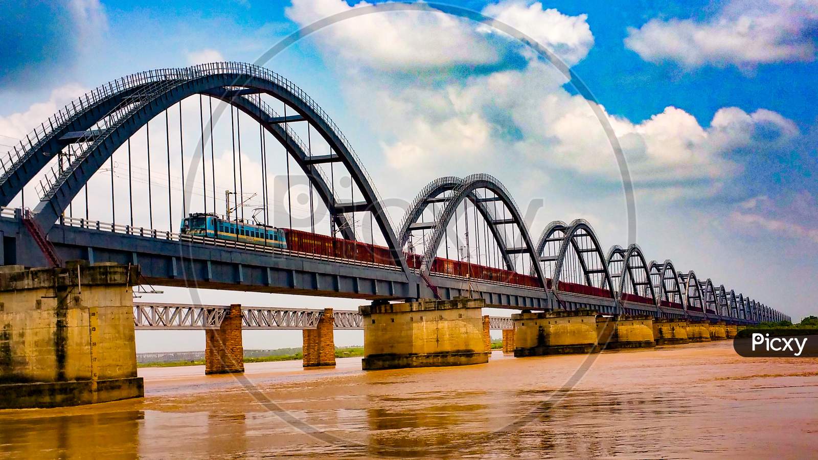 Train passing on arch railway bridge across the Godavari river.