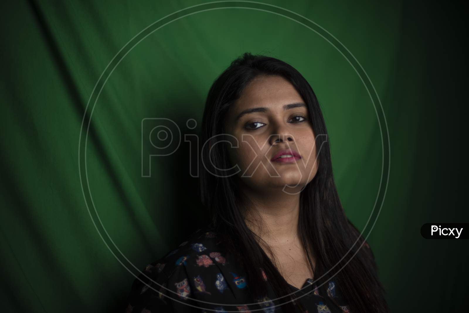 Image of Portrait of young brunette Indian Bengali brunette plus size woman  in western dress in green copy space studio background. lifestyle and  fashion.-MA981842-Picxy