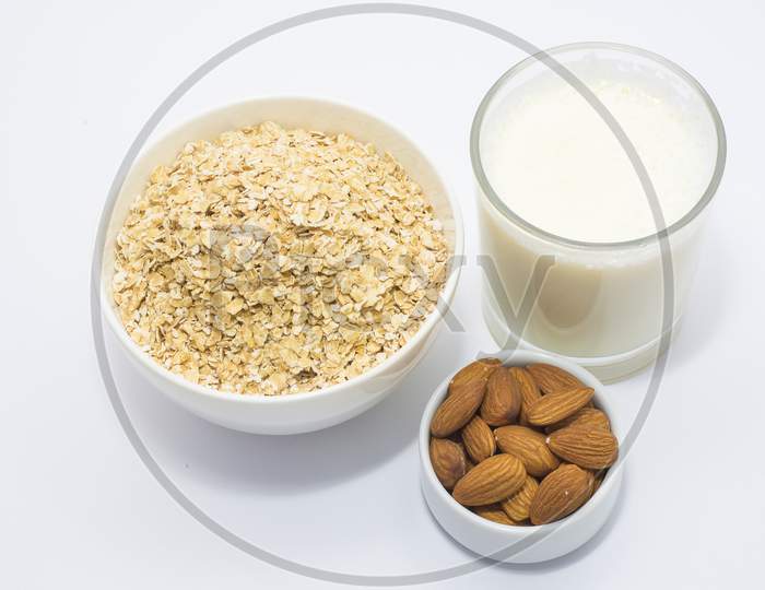 Healthy breakfast ingredients glass of milk, Almond nut and oats .