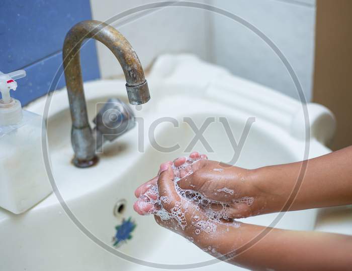 Washing Hands With Soap And Hot Water At Home Bathroom Sink Kid Cleansing Hand Hygiene For Coronavirus Outbreak Prevention. Corona Virus Pandemic Protection By Washing Hands Frequently. Closeup Of Hand Washing With Soap.