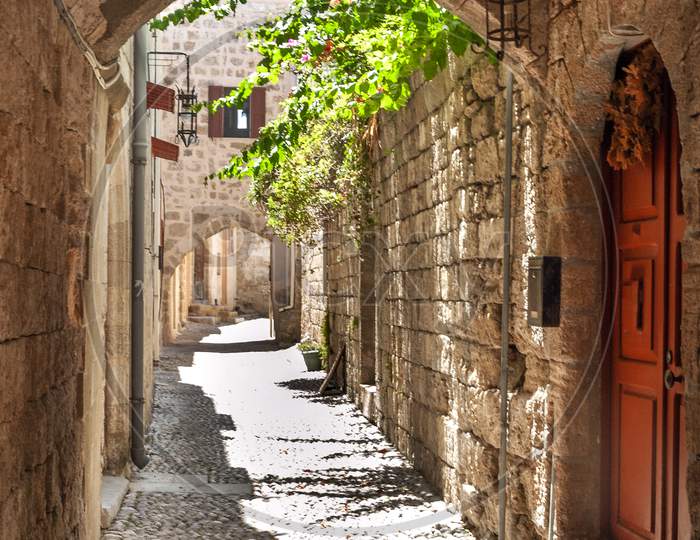 One of the network of many intricate deserted streets of the old town of Rhodes at midday.