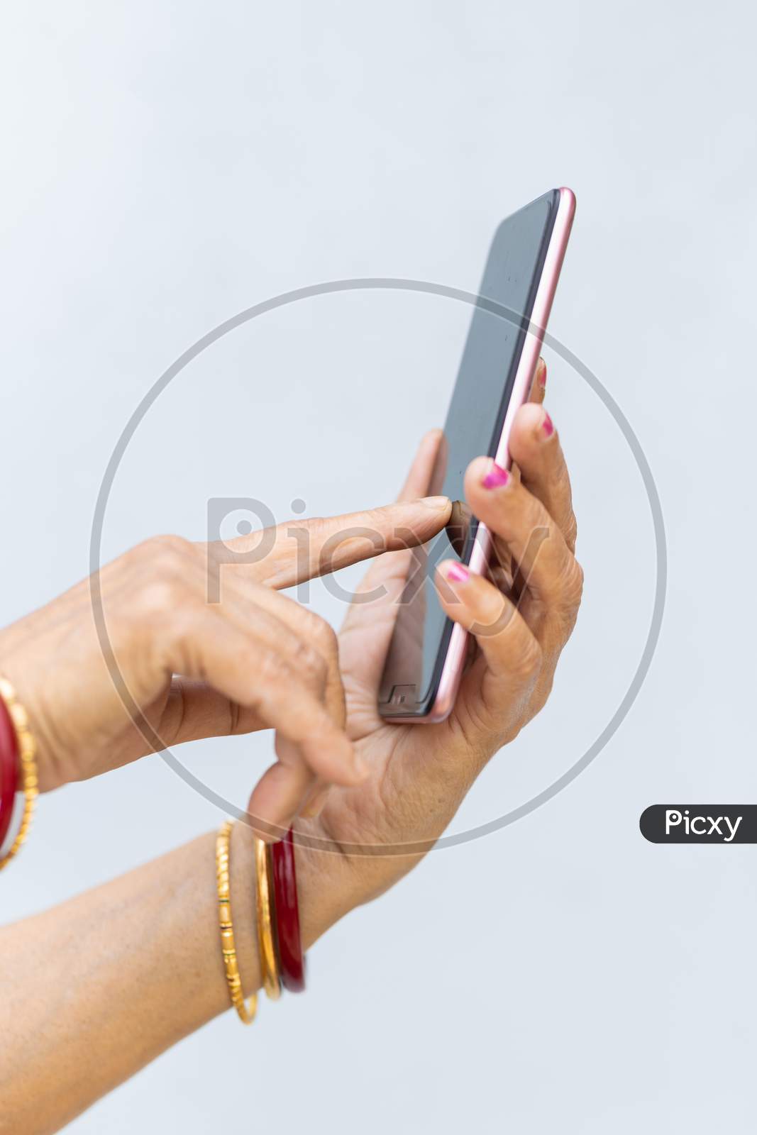 Senior Woman Hand Using Mobile Phone Against Plain Background