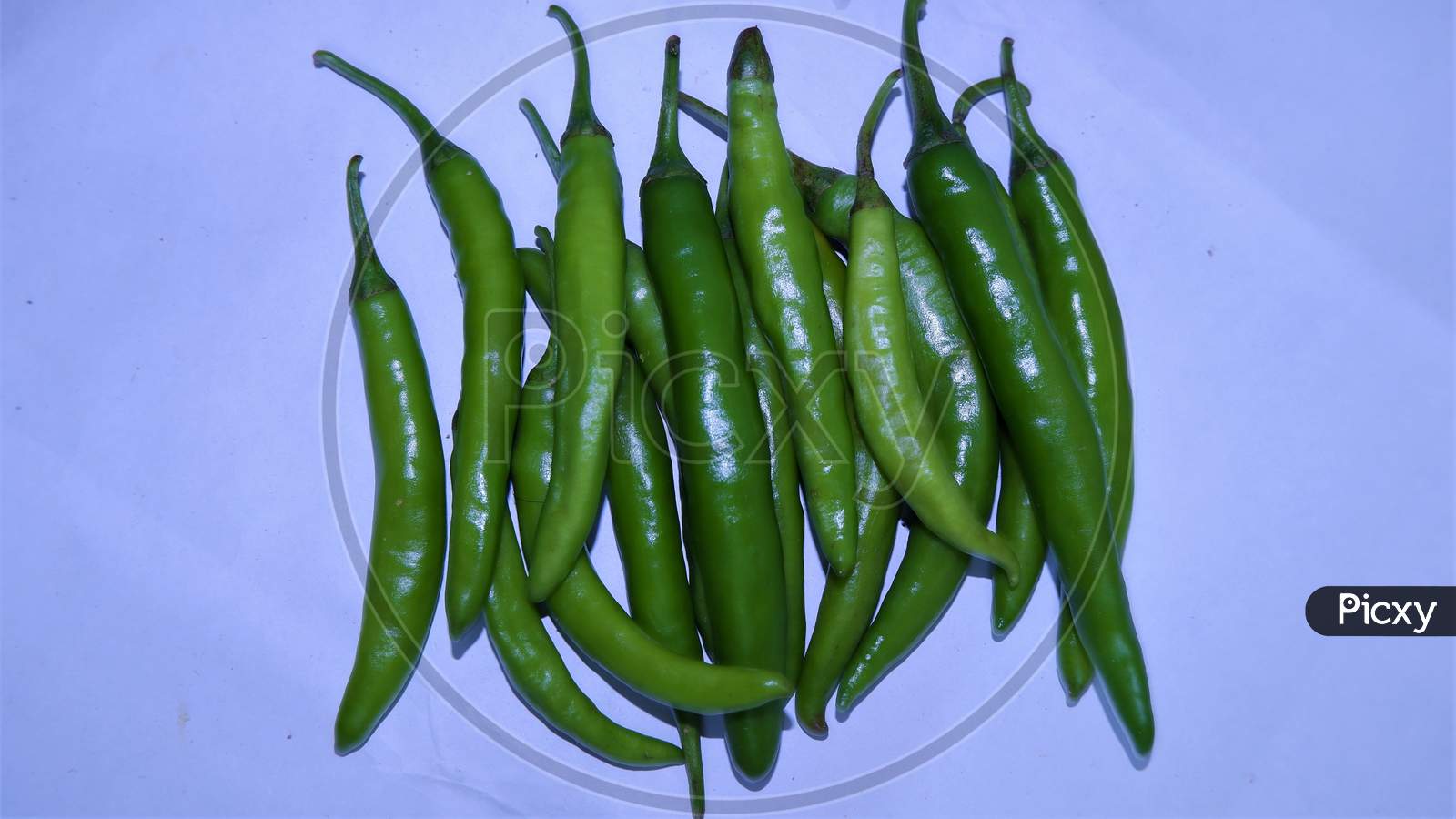 green chilies on a white background