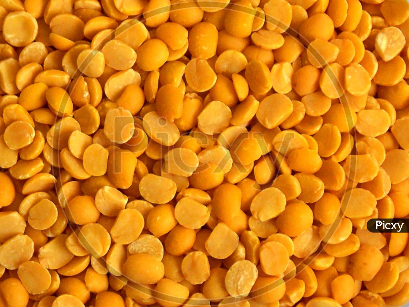 Yellow chopped peas close up,background of yellow peas.Yellow split chickpea peas boot chana dal lentil pulse bean on white background,top view.healthy food.