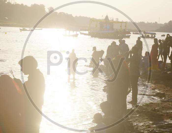 Backlight Image of People offering Prayer in Narmada River
