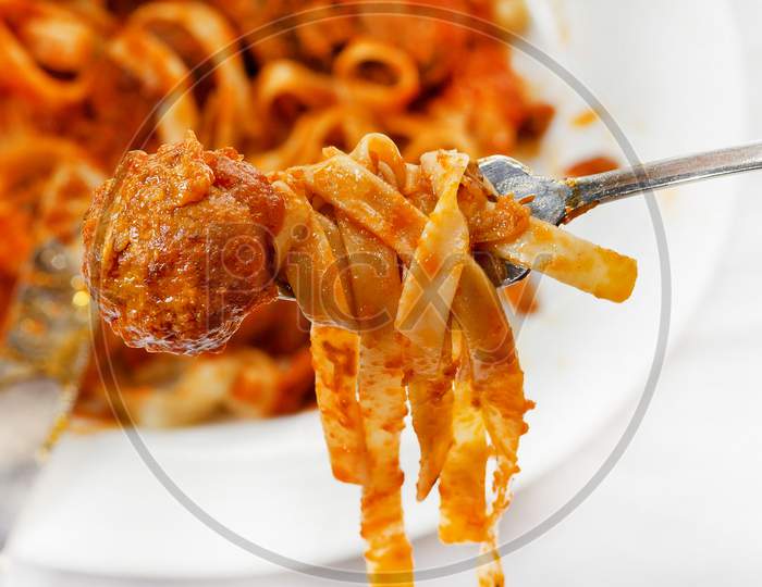 Fettuccine And Meatballs On A Fork Close-Up.