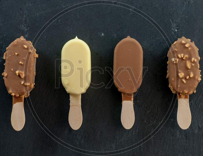 assorted mini ice creams on stick on black