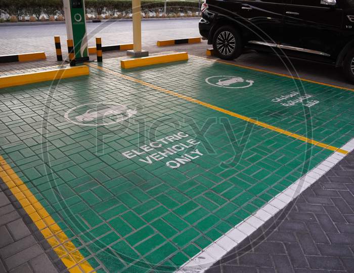 Green Electric Vehicle Charging Station Sign In A Parking Bay. Electric Vehicle Parking Space. Electric Car Charging Station. Dubai Uae December 2019