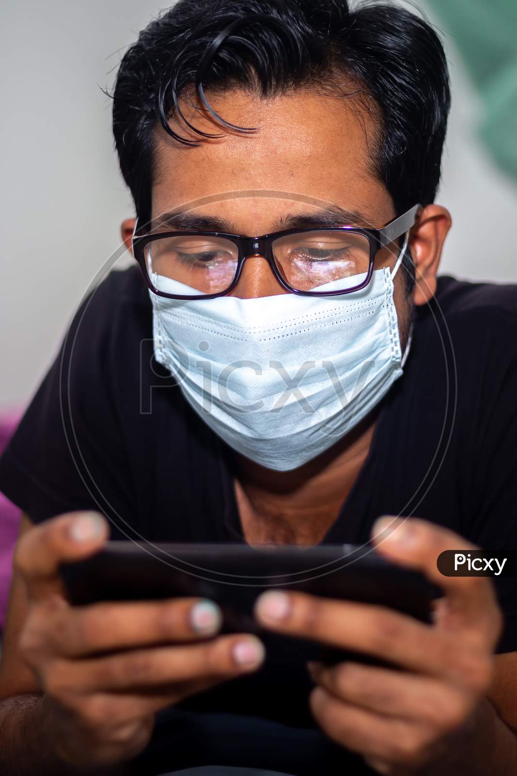 Portrait Of A Young Man Playing Mobile Video Games At Night Deu To Coronavirus Epidemic.