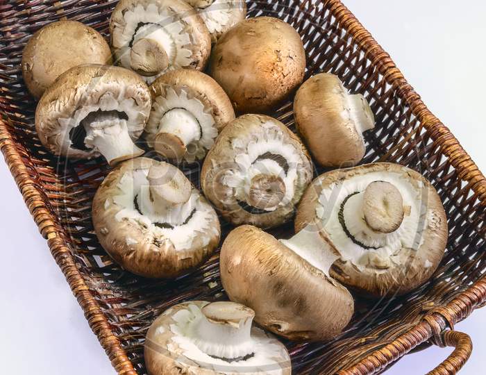A collection of cremini mushrooms in a basket