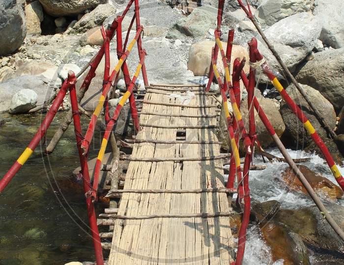 Narrow Footbridge Over A Stony Mountain River