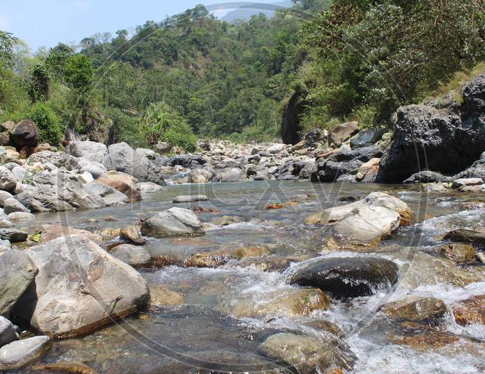 View Of River Water Flowing On Stone Banks