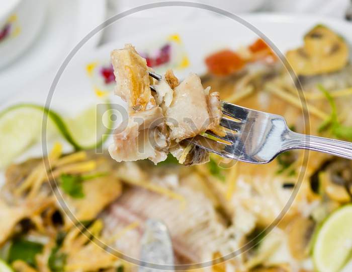 Pieces Of Pomfret Fish On A Fork Close-Up.