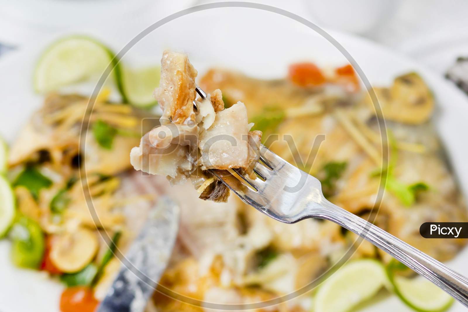 Pieces Of Pomfret Fish On A Fork Close-Up.