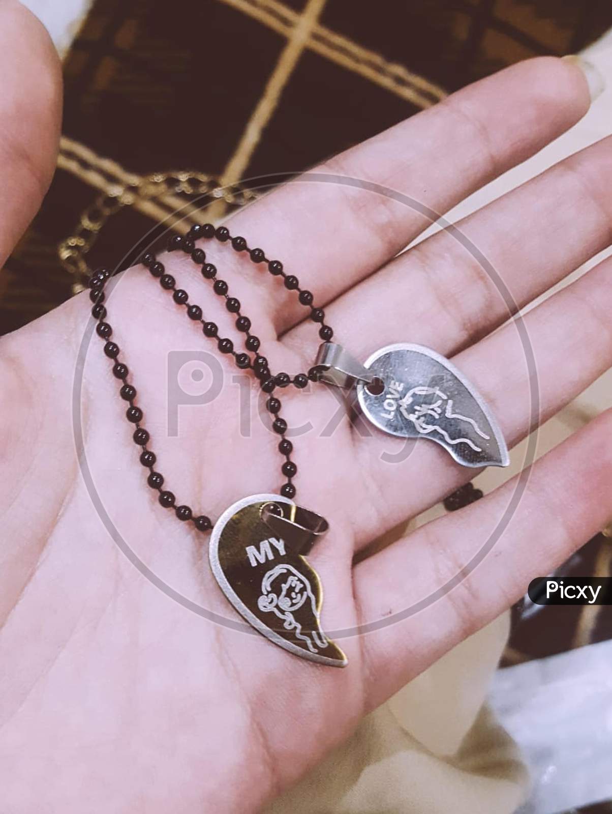 My Love two necklaces of heart with black chain in someone's hand
