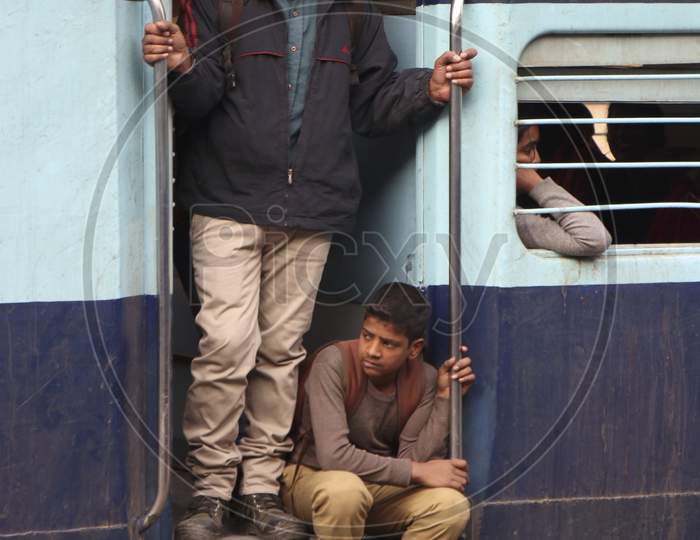 Boy sitting on the gate of the train waiting for it to start