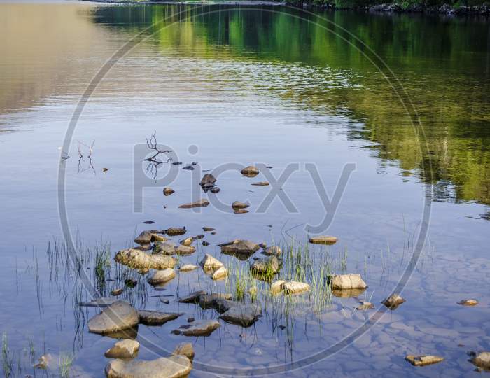 Vertical shot of a calm lake with stones