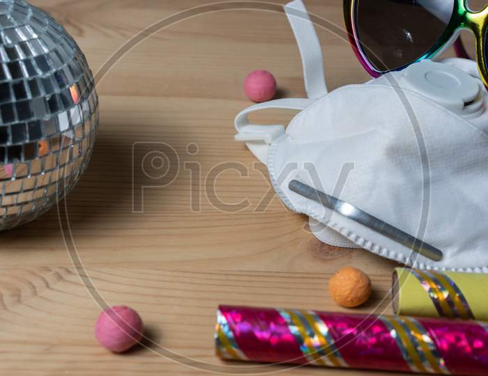 Party globe with mask protection on the wooden ground.