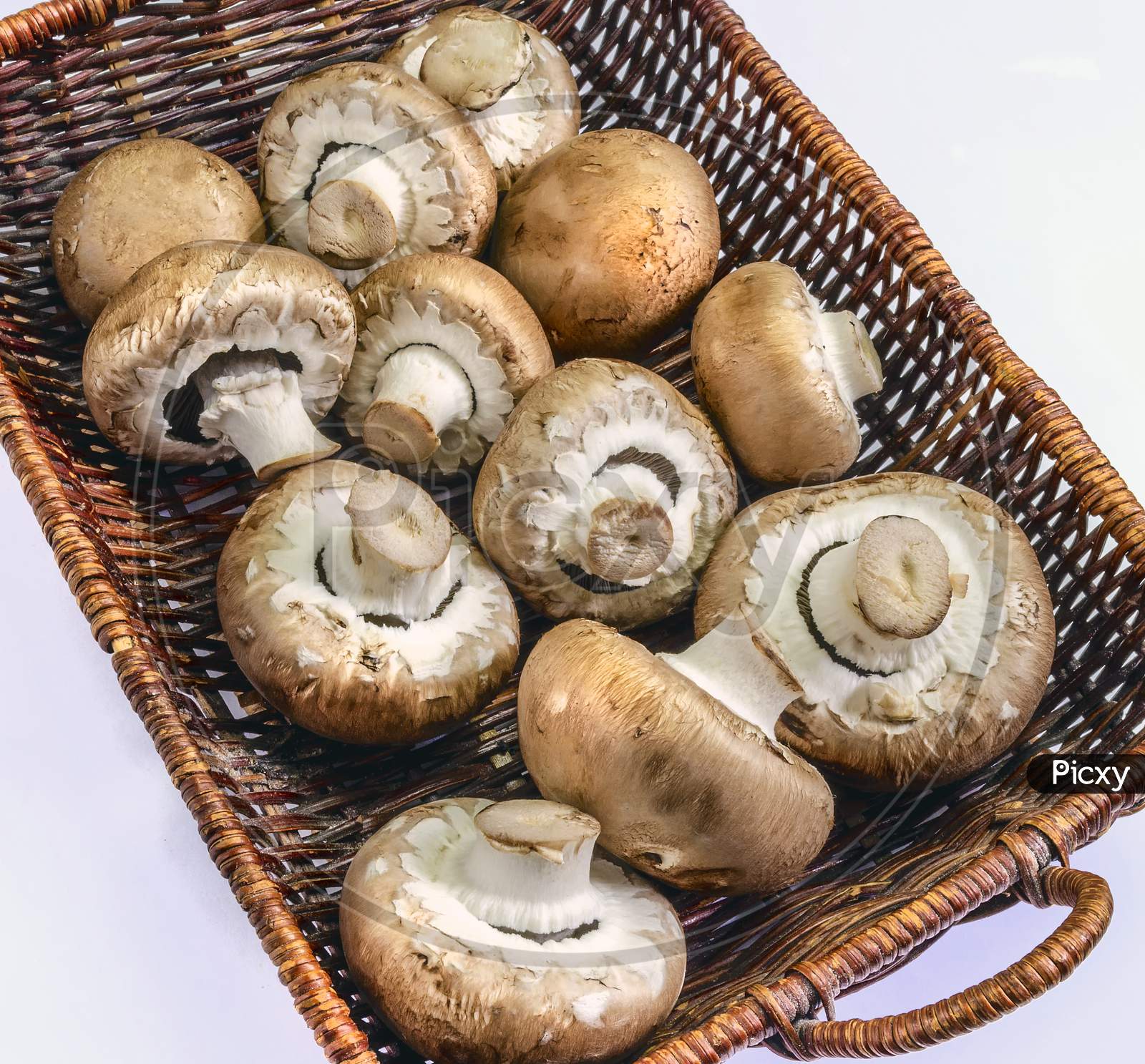 A collection of cremini mushrooms in a basket