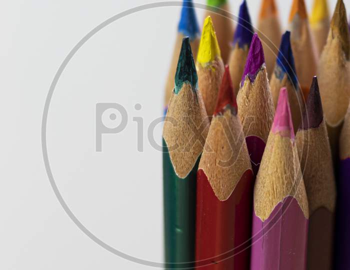 Group Of Colorful Wooden Pencils Close-Up Shot With Selective Focus Or Shallow Depth Of Field On White Background And Space For Text On Left Side
