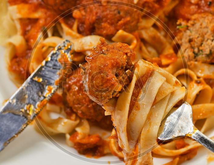 Fettuccine And Meatballs On A Fork Close-Up.