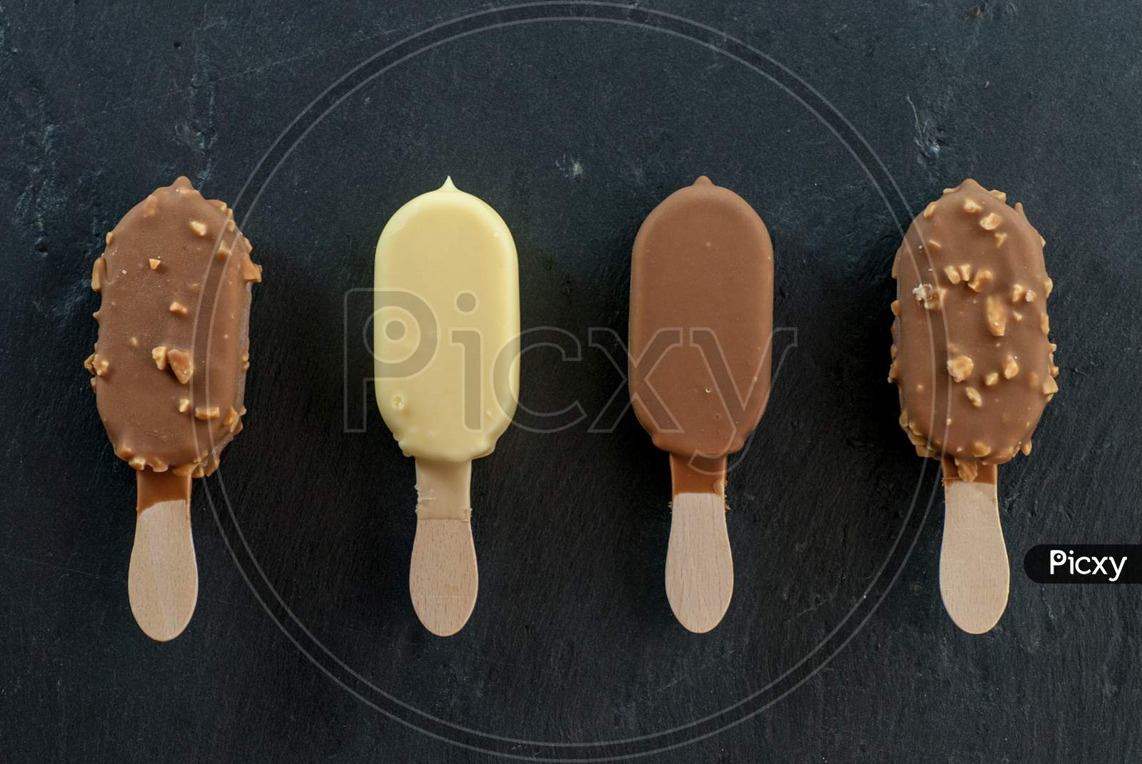 assorted mini ice creams on stick on black