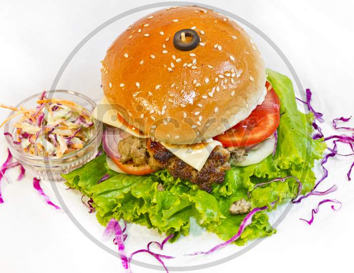 A Big Size Burger Patties From Ground Beef With Lettuce Leaf And Coleslaw Salad.