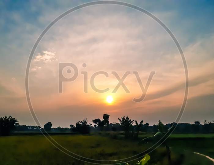 Indian Farmland And Colorful Sunshine At Sunset, White Clouds In The Blue Sky And Beautiful Surrounding.