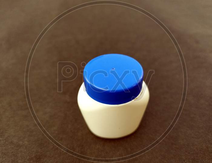 a white and blue plastic bottle isolated on seamless background