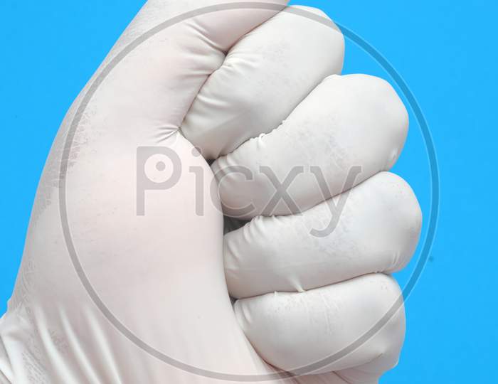 Showing Gesture,Doctor Hand In Sterile Gloves On Blue Background
