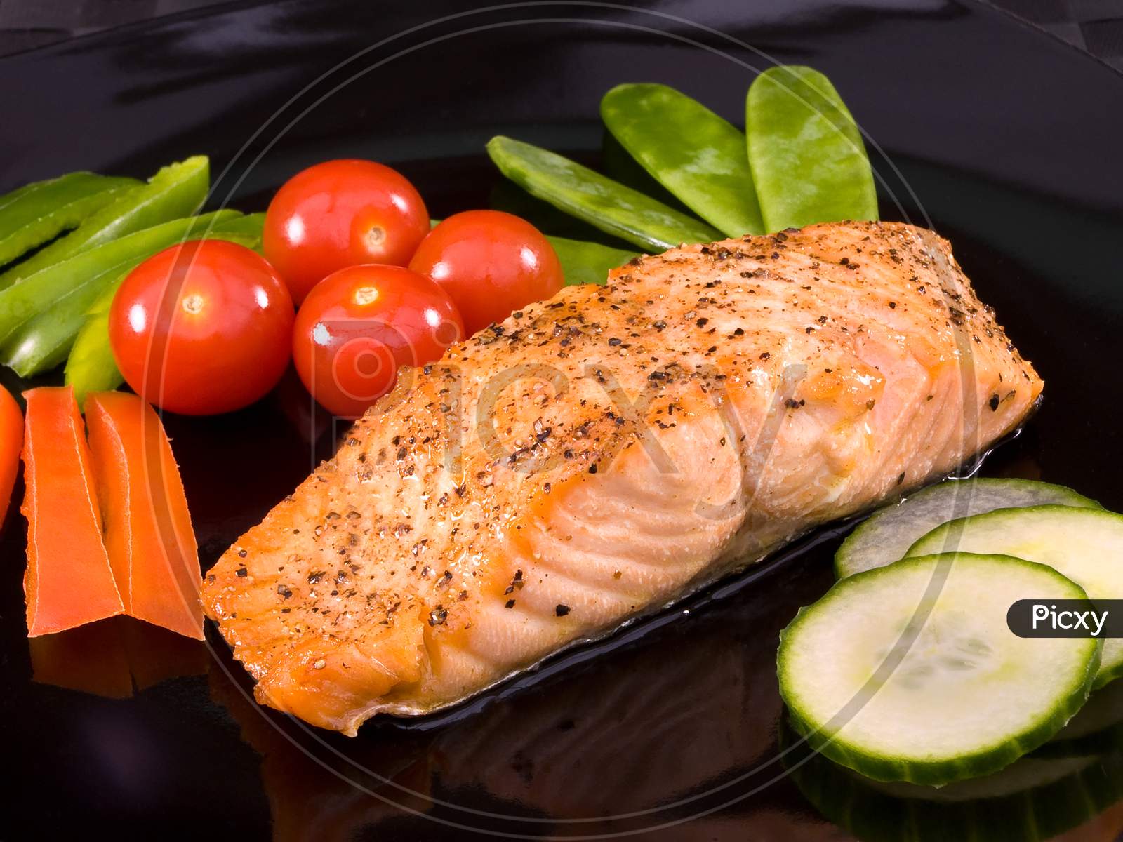 Grilled salmon on a plate with salad ready for serving.