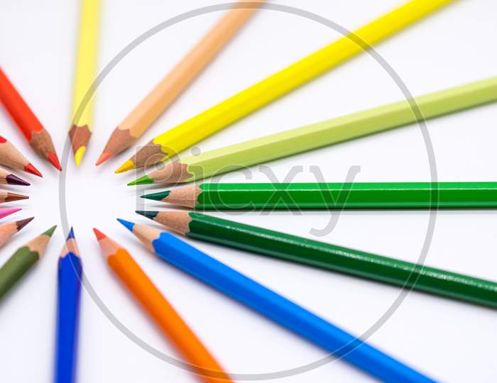 colored crayons arranged on white background abstract conceptual photo