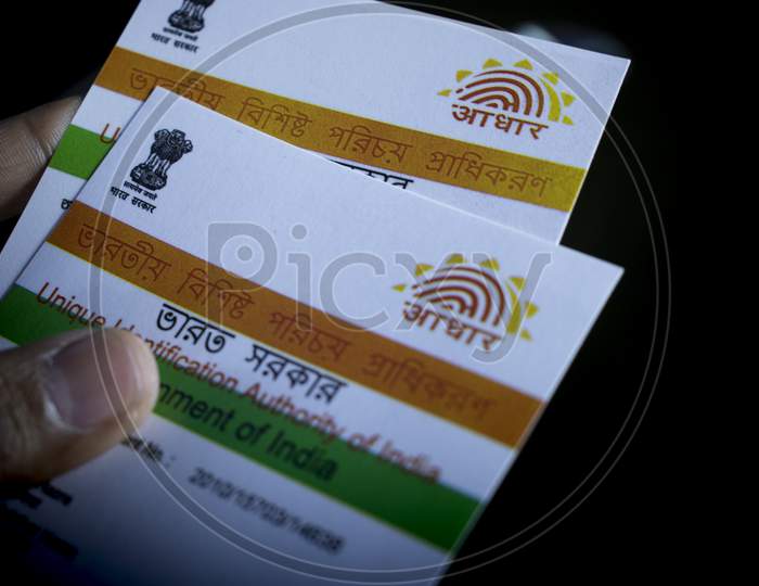 Aadhaar Card Identity Of India Held In Hand On Black Background With Selective Focus