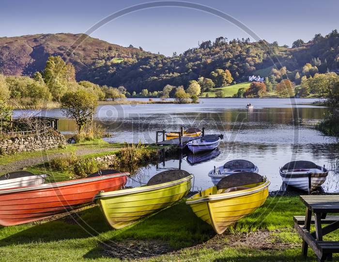 Several colourful boats at rest by a lake