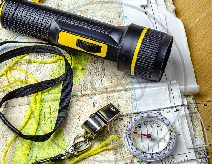 A hill walking map with compass torch and whistle.