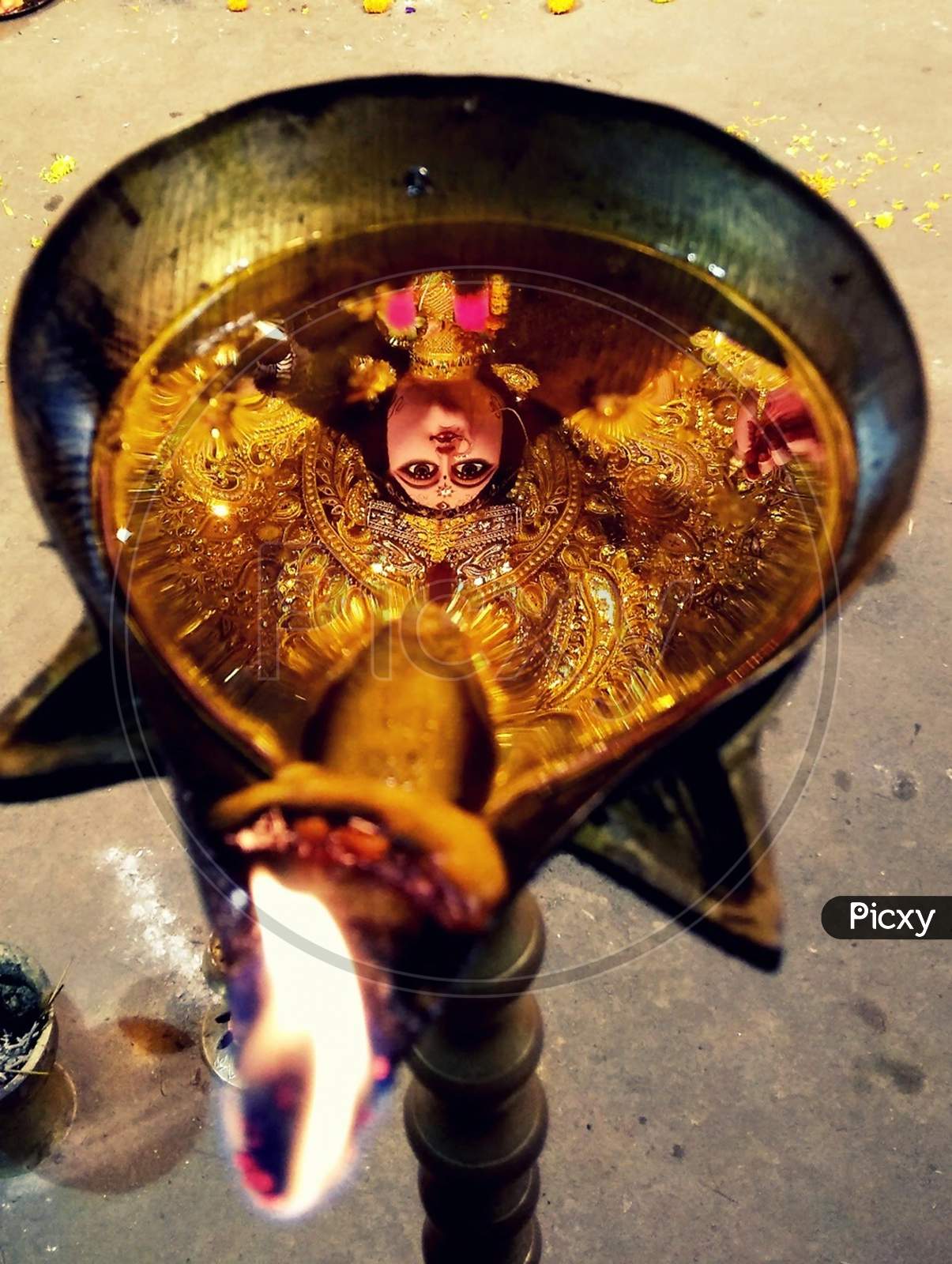Reflection Of Deity In A Oil Lamp Of A Hindu Temple At Evening