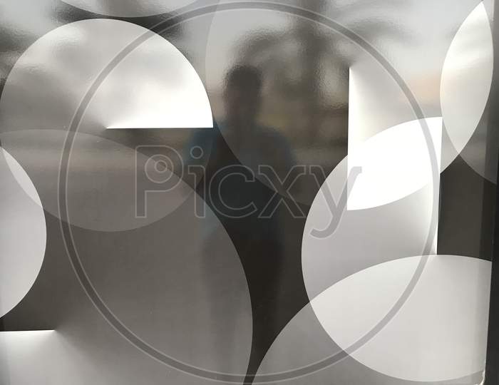 White And Black Circles Designed Over A Sticker For An Glass Partition Of Atm For Privacy Purpose While Cash Out In Public