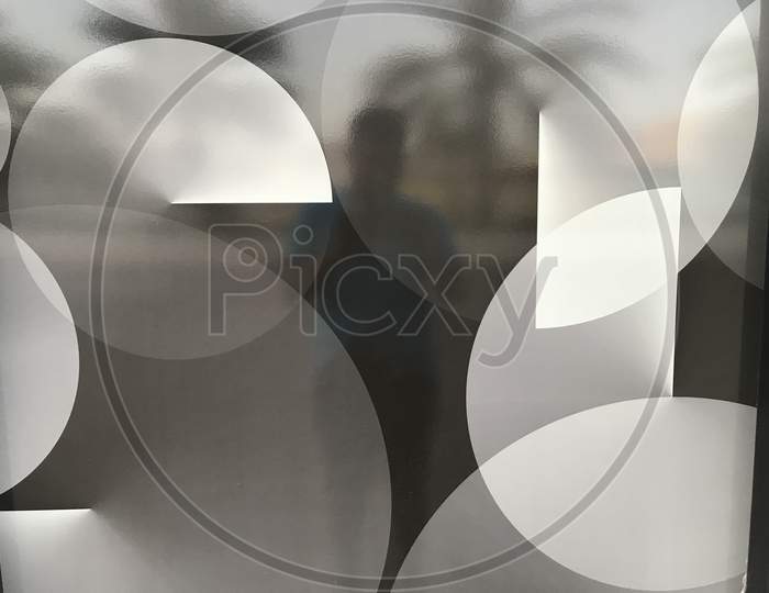 White And Black Circles Designed Over A Sticker For An Glass Partition Of Atm For Privacy Purpose While Cash Out In Public