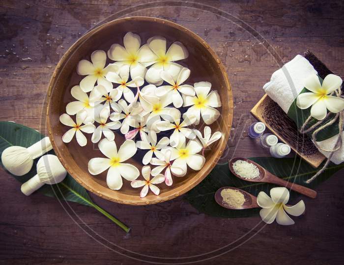 White flower in water tub with wooden background