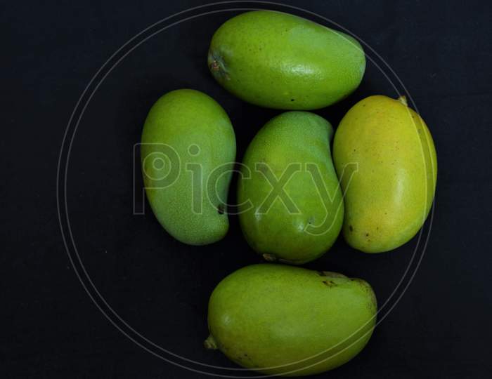 assortment set of green mangoes in black background