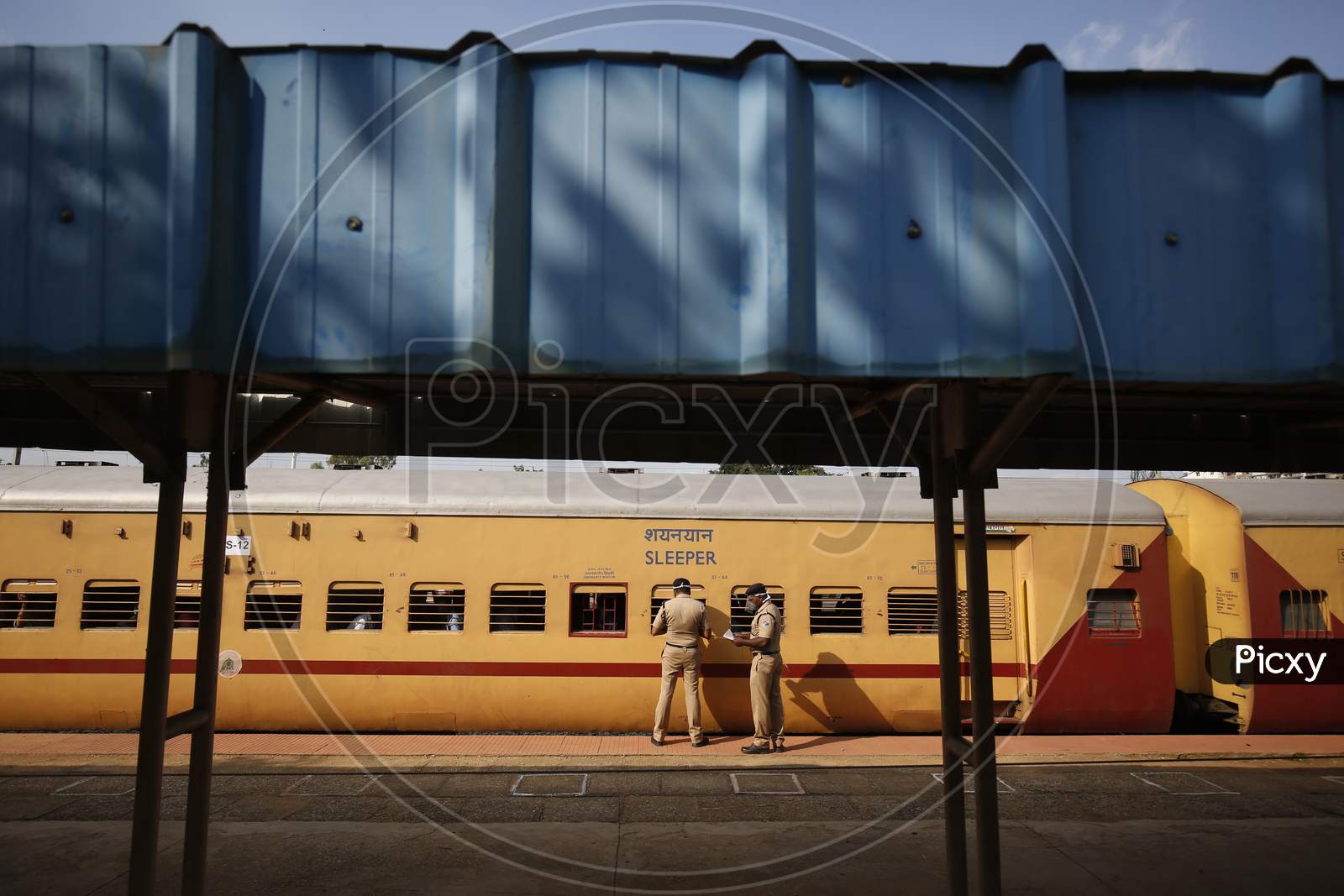 Railway Protection Force (RPF) personnel check travel documents of migrant workers travelling to Danapur, Bihar in a special train arranged by the government to repatriate migrant workers at the Chikkabanavara Junction Railway Station on the outskirts of Bangalore, India.