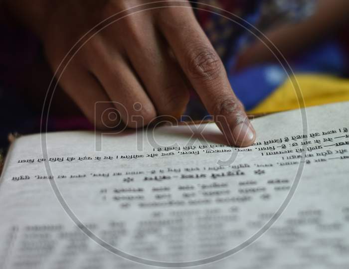 India - May 09, 2020: closeup of an Indian girl reading a holy ramayan and bhagwat geeta at home, with blur background.