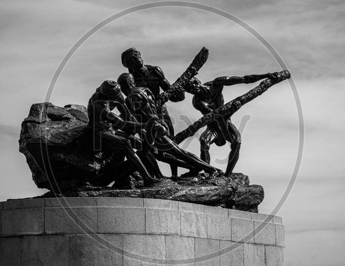 greyscale statue of workers in marina