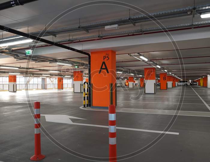 Dubai Uae December 2019 Underground Parking Which Is Almost Empty. Empty Garage In Basement Of Office Building. Reinforced Concrete Monolithic Floors In Basement. Urban, Industrial Background.