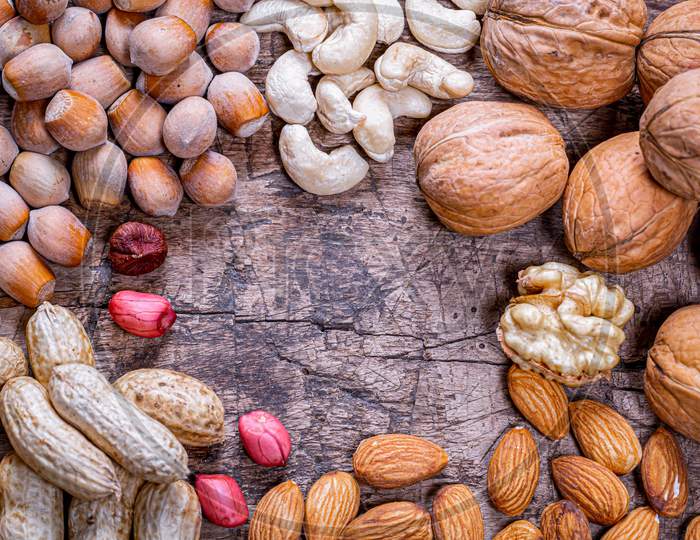 Peanuts, Walnuts, Almonds, Cashews And Hazelnuts On Old Wooden Background